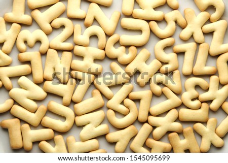 Background from randomly lying cookies alphabet letters. Baby food or back to school concept.