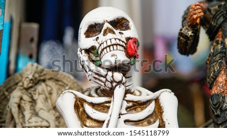 Mexican handicraft: Skull with rose in the mouth made of clay and hand painted, usually used as an ornament in Day of the Dead offerings