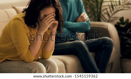 sad wife and husband, angry couple in bedroom. unhappy couple concept. usband and wife are sitting on the couch, looking away from each other. husband is not ready to have a dialogue