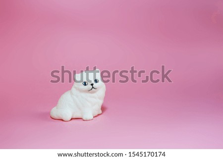 White Persian cat toy isolated in pink background  