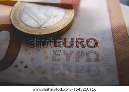 Macro photo of a coin in 1 Euro in a dark environment on a blurred background banknote in 50 euro. Money background. Extremely small depth of field.