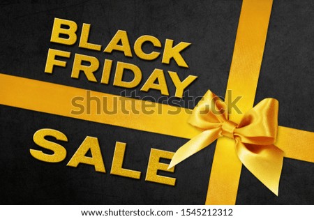 Black Friday sale text write on black gift card with golden ribbon bow