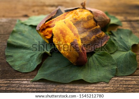 Roasted japanese sweet potato with smoke put on leaf and wooden background