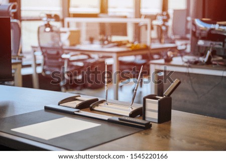 Office workplace with stationery. Boss, chief, supervisor or head of company working place in modern office. Comfortable work table and leather computer chair. Blurred