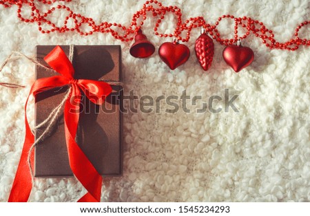 Beautiful gift box with red ribbon. Box for a gift. White cozy plaid. New year, Christmas. On the eve of the holiday.