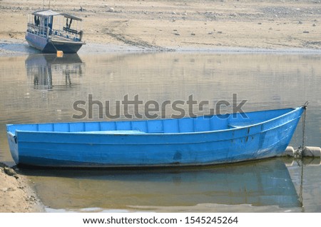 Blue boat anchored  on the lake shore