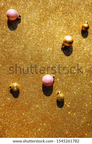 Christmas composition. New Year or Christmas pattern flat lay top view Xmas holiday celebration sparkling golden decoration on golden background with copy space. Template of greeting card