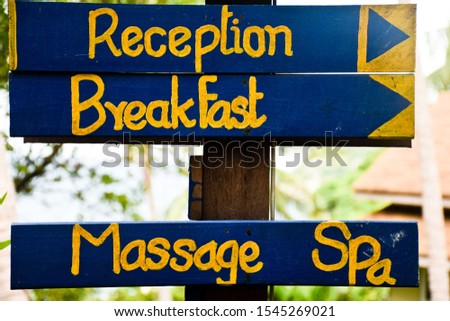 Hotel reception sign in the garden. Breakfast and massage spa sign.