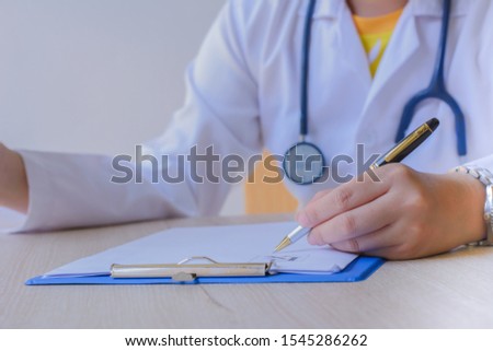 Woman  doctor uses a laptop to research something while working in her office. 