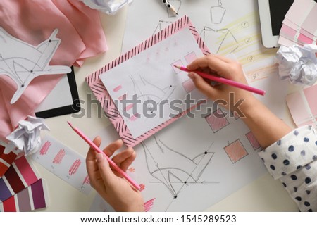 Female fashion designer working at white table, top view