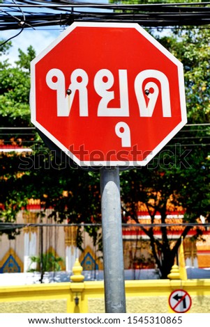 warning road sign in Thai language, "STOP" traffic sign in Thailand