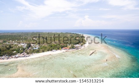 Gili islands a summer paradise place with coral reef and boats. In the picture we can see the shore at gili trawangan island with some diving boats around. The picture was taken with a drone