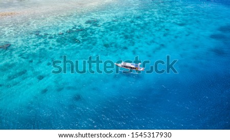 Gili islands a summer paradise place with coral reef and boats. In the picture we can see a diving boat with blue water around gili trawangan island