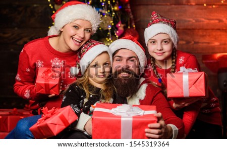Christmas joy. Christmas tradition. Happy holidays. Parents and children opening christmas gifts. Cheerful family concept. Father Santa claus and mother little daughters christmas tree background.