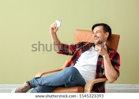 Handsome man taking selfie at home