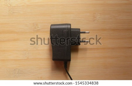 Black color 2 pin power plug adapter on wooden table