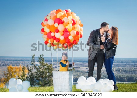Happy family mother, father and son together in nature with balloon for air travel