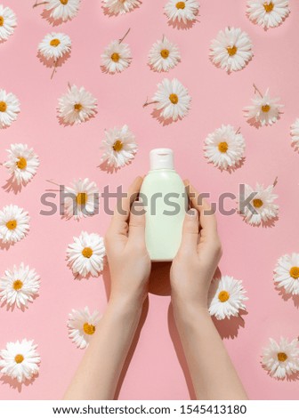 The concept of skin care face, body. Hair care. Bottle of Natural Cosmetics on pastel background with camomiles. Pattern