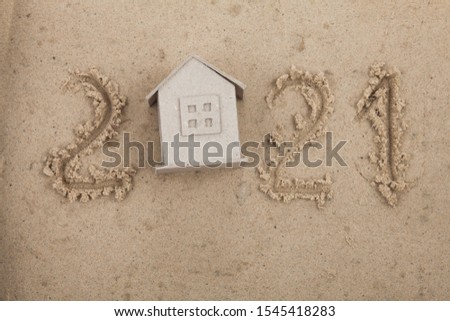 New Year 2021 concept with a cardboard house on wet sand