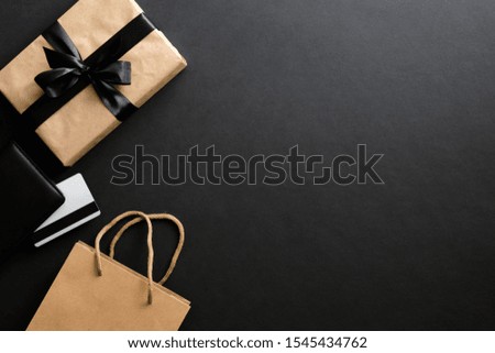 Black friday sale concept. Frame made of gift box, credit card, shopping bag over black background