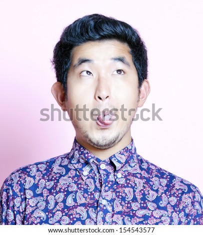 Young Geeky Asian Man in colorful shirt pulling funny face