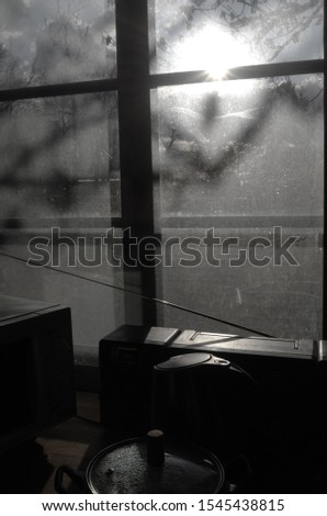 strong autumn light through a dirty window with lots of objects on the window sill
