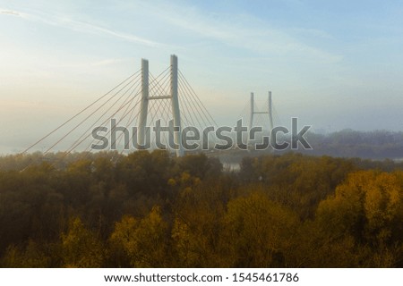 Aerial view of the Siekierkowski Bridge in beautiful fog. Warsaw, Poland. Drone shot at the traffic of vehicle traveling in traffic jam on a bridge over a river.