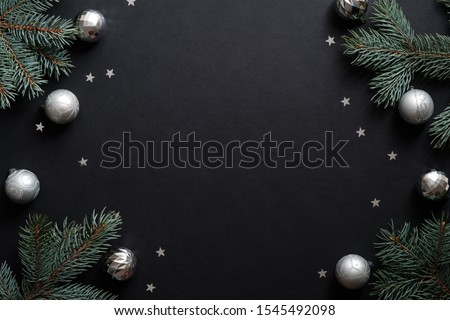 Black christmas banner mockup with fir tree branches, silver balls, confetti. Christmas frame, greeting card template, web banner mockup. Flat lay, top view, copy space