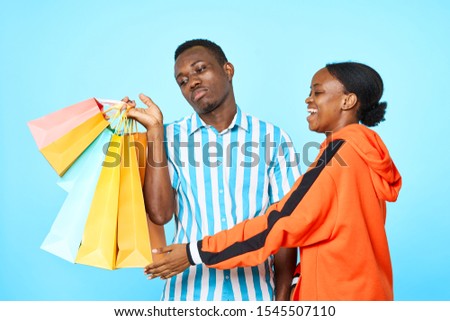 A man with multi-colored bags and a happy African American woman