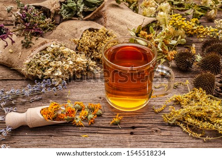 Tea with honey. Herbal harvest collection and bouquets of wild herbs. Alternative medicine. Natural pharmacy, self-care concept. Old wooden boards background Royalty-Free Stock Photo #1545518234