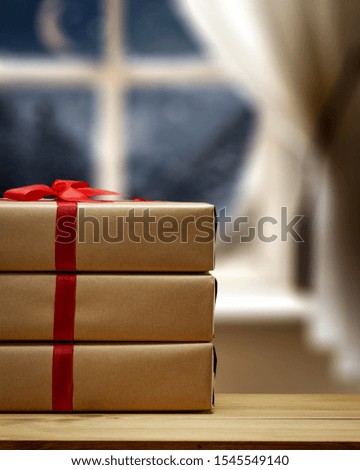 Winter gift on desk and blurred background of window. Free space for your product. Christmas time. 