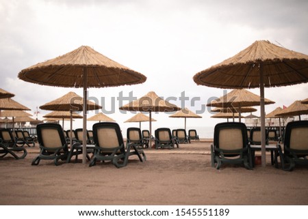 Sunbeds on the beach in cloudy weather. 
Turkey. Antalya.  
Mediterranean Sea.