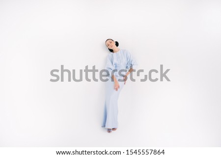 Beautiful caucassian model wearing Asian traditional dress for Muslim woman isolated over white background.Eid ul fitr fashion and beauty.