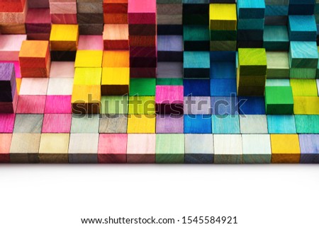 Spectrum of stacked multi-colored wooden blocks with white space in front. Background or cover for something creative, diverse, expanding,  rising or growing. shallow depth of field.