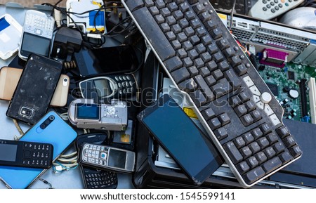 Close up on pile of mixed electronic waste, old broken computer parts and cell phones Royalty-Free Stock Photo #1545599141