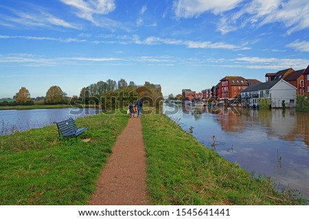 A family walking the footpath between the River Avon and the River Severn both in flood conditions due to recent heavy rain and a 4 star bore, Tewkesbury, Gloucestershire, UK