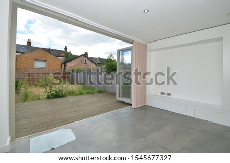 Garden View via bifolding doors and Solid Polished Concrete Flooring in Lodnon UK Royalty-Free Stock Photo #1545677327