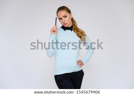 Portrait of a pretty blonde financial secretary girl with long curly hair in a business suit standing in the studio on a white background with emotions in different poses.