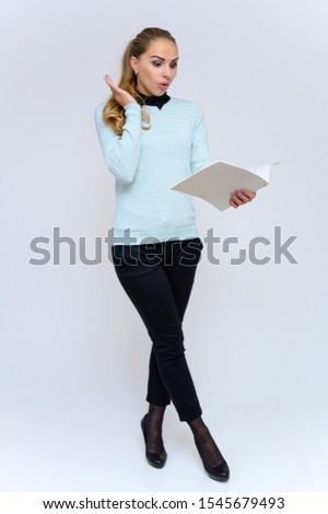 Full length vertical portrait of a pretty blonde financial secretary girl with long curly hair in a business suit standing in the studio on a white background with emotions in various poses.