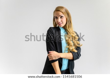 Portrait of a pretty blonde secretary girl with long curly hair in a business suit standing in the studio on a white background with emotions in different poses. Art, business, beauty.