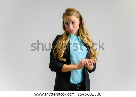 Portrait of a pretty blonde secretary girl with long curly hair in a business suit standing in the studio on a white background with emotions in different poses. Art, business, beauty.