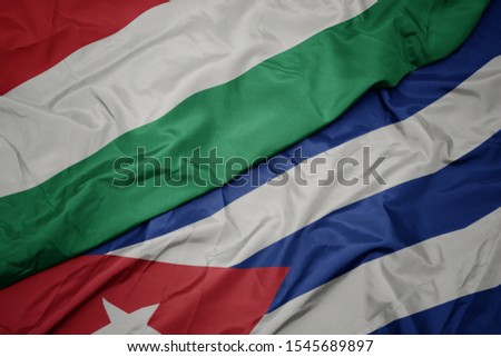 waving colorful flag of cuba and national flag of hungary. macro