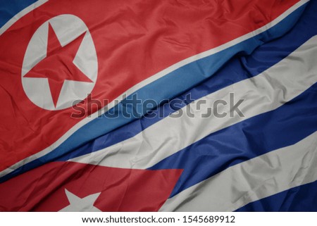 waving colorful flag of cuba and national flag of north korea. macro