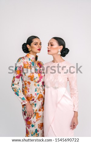 Beautiful girl wearing Baju Kurung (Asian Malay traditional dress) isolate over white background.Modern female fashion fro Eid Ul Fitr celebration or formal event.