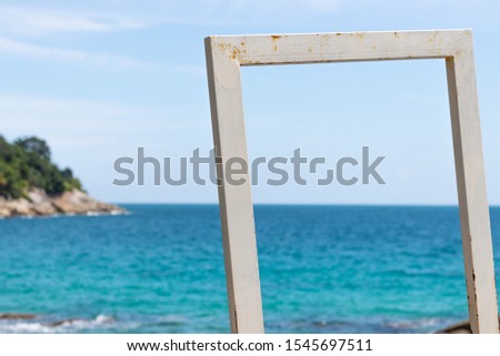 The white picture frame is slightly rusted. Leave space for putting images or text. The backdrop is a beautiful sea.