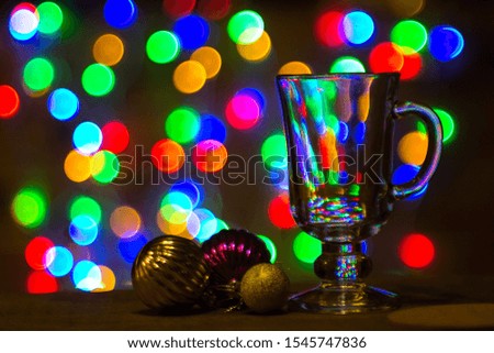 Christmas balls and glass for wine on the background of a garland