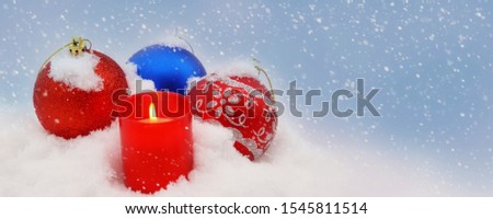 blue red Christmas balls in the snow candle. Christmas border