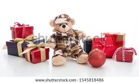 Army, military at Christmas concept. Cute teddy bear in soldier uniform and gift boxes standing isolated against white background