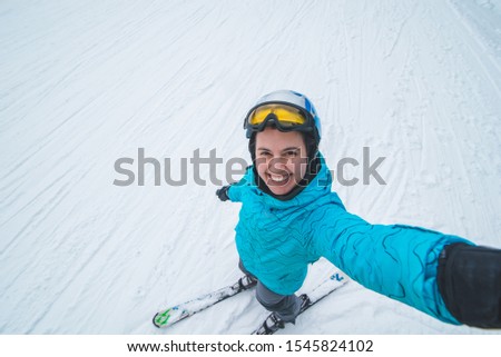 young pretty woman making selfie while skiing.