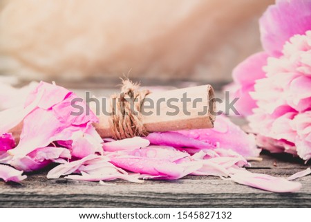 Roll of old paper on rose petals. Love letter, a wedding invitation. Romantic atmosphere of  holiday.
